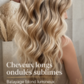 Femme avec des cheveux longs et ondulés, mettant en valeur un balayage blond et des lowlights caramel.