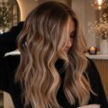 Femme avec de magnifiques ondulations brunes dorées, coiffure tendance.